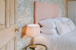 View of a bedroom showing decorative wallpaper and headboard - perfect accommodation for a luxury hen weekend or family gathering