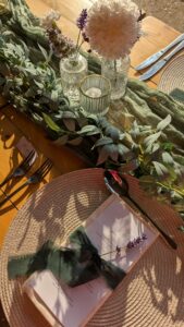 A table place setting with a eucalyptus garland, candles and fresh lavender